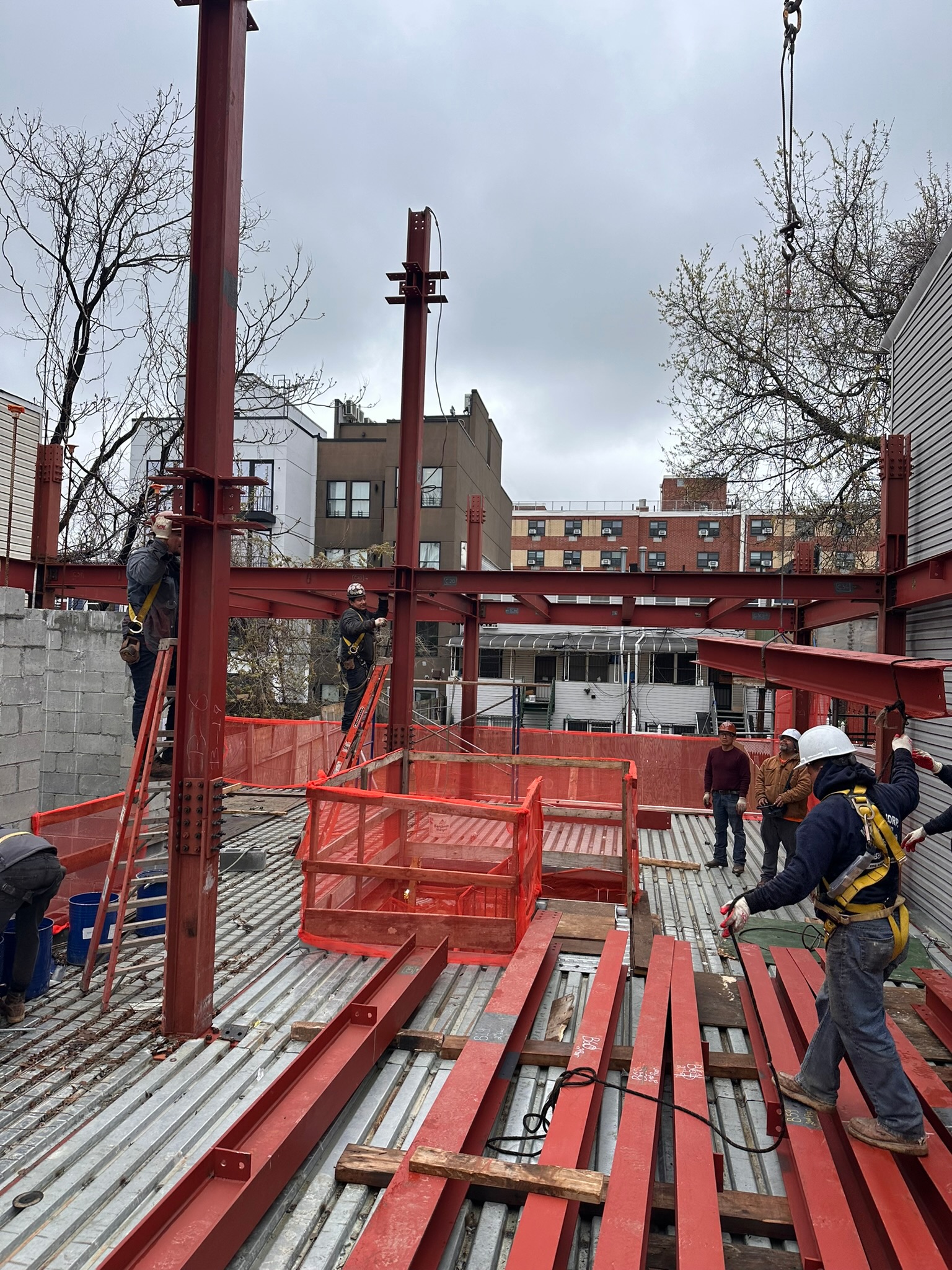 Construction crew positioning structural steel on a neighborhood jobsite
